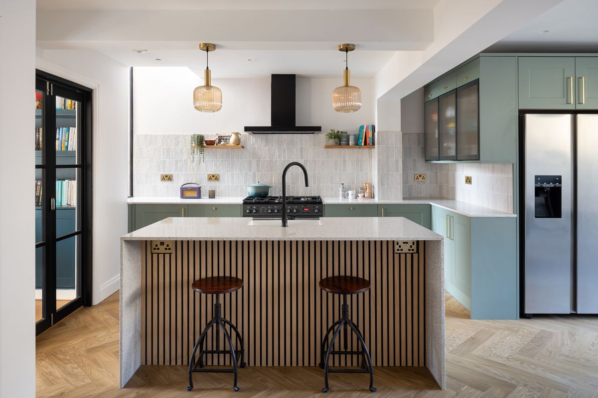 Kitchen with fluted island, bar stools and sage-green cabinetry – Beech Hall Crescent by Patrick Crowe Architects. Photograph by Daniel Avery.