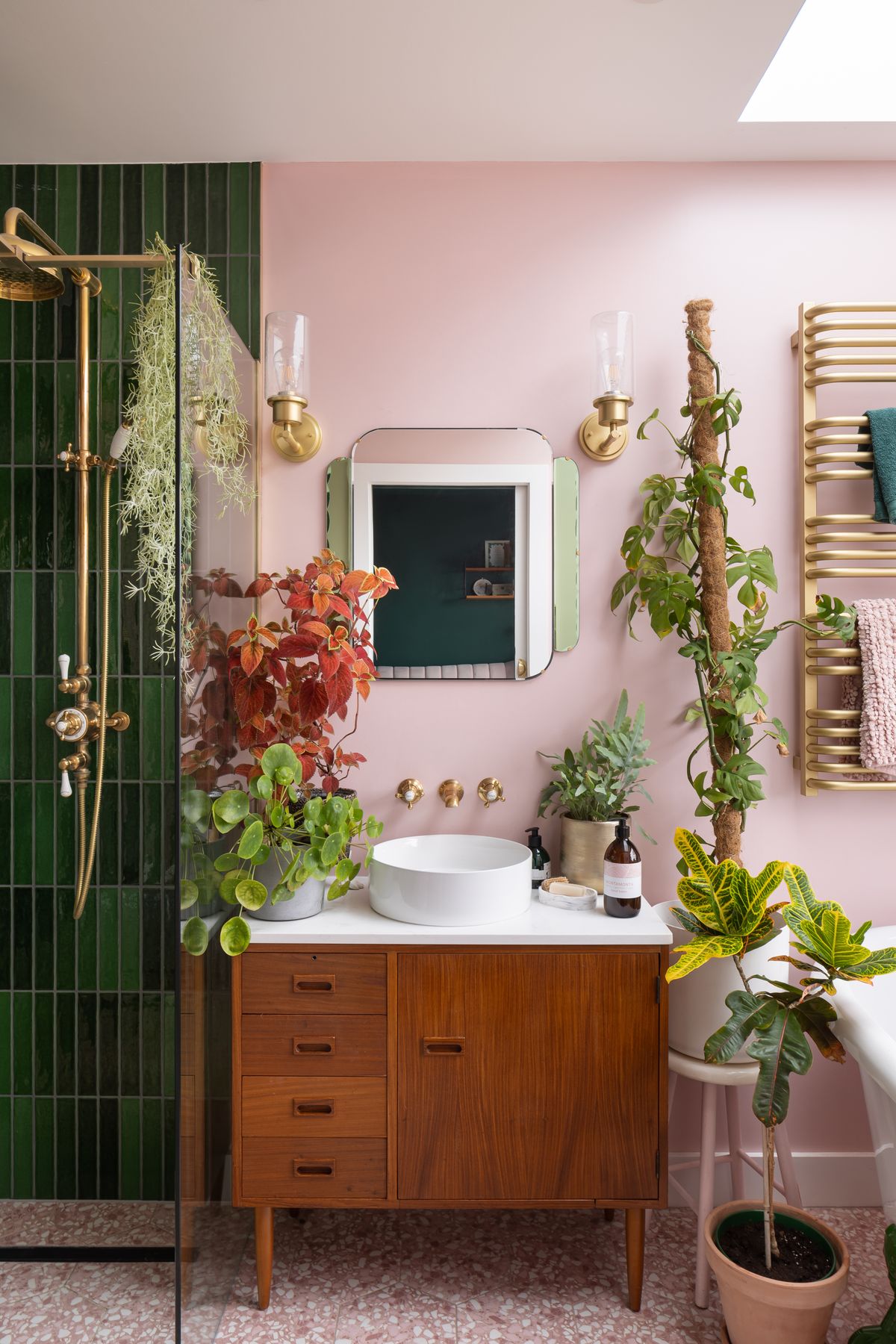 Bathroom with pink walls, green tiled shower, brass fittings and a mid-century vanity – Chester Road by Sweetch Architects. Photograph by Daniel Avery.